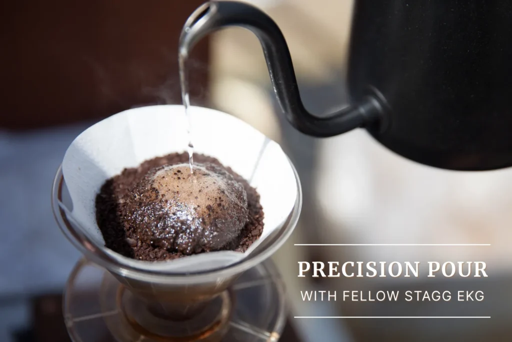 Precision pour from the Fellow Stagg EKG kettle creating a coffee bloom in a paper filter.