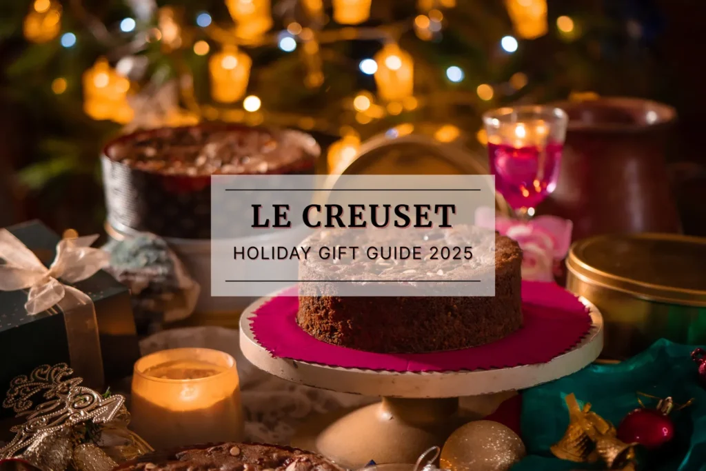 Festive holiday table with wrapped gifts, candles, and a cake on a stand, styled with warm lights for a Le Creuset holiday gift guide.