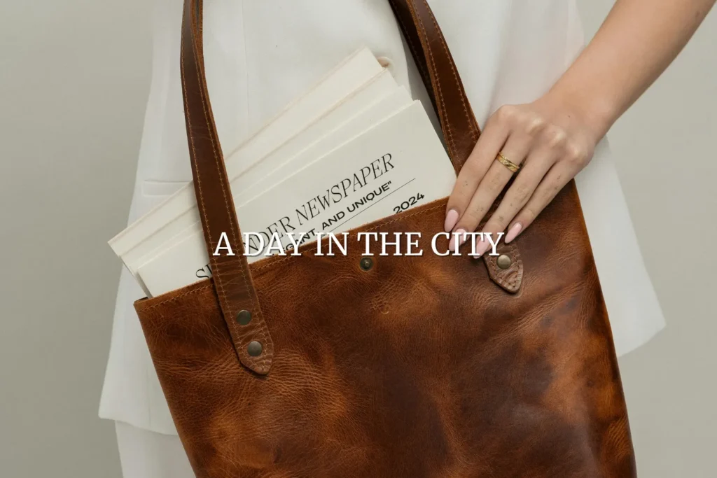 Leather tote bag carried with a folded newspaper, styled for a day in the city and fashionable everyday gifts for her.