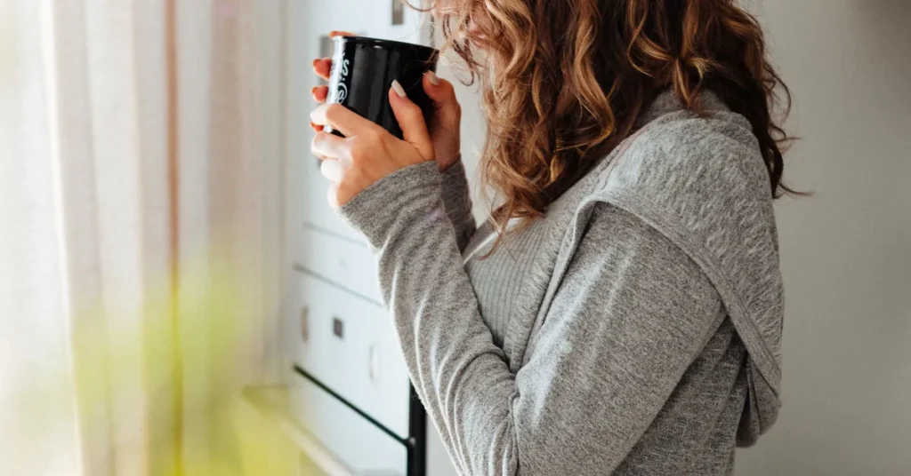 person holding coffee in natural light showing everyday home brewing routine