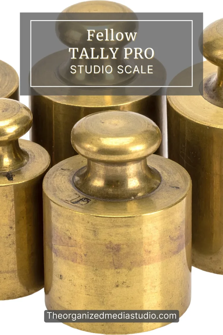 Brass calibration weights arranged in studio lighting with overlay text for Fellow Tally Pro Studio Scale
