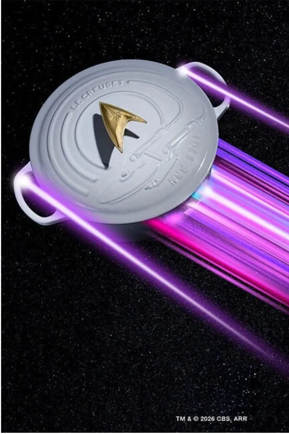 Le Creuset Star Trek collection Enterprise Dutch oven with Starfleet Delta knob against a black space background with purple light trails.